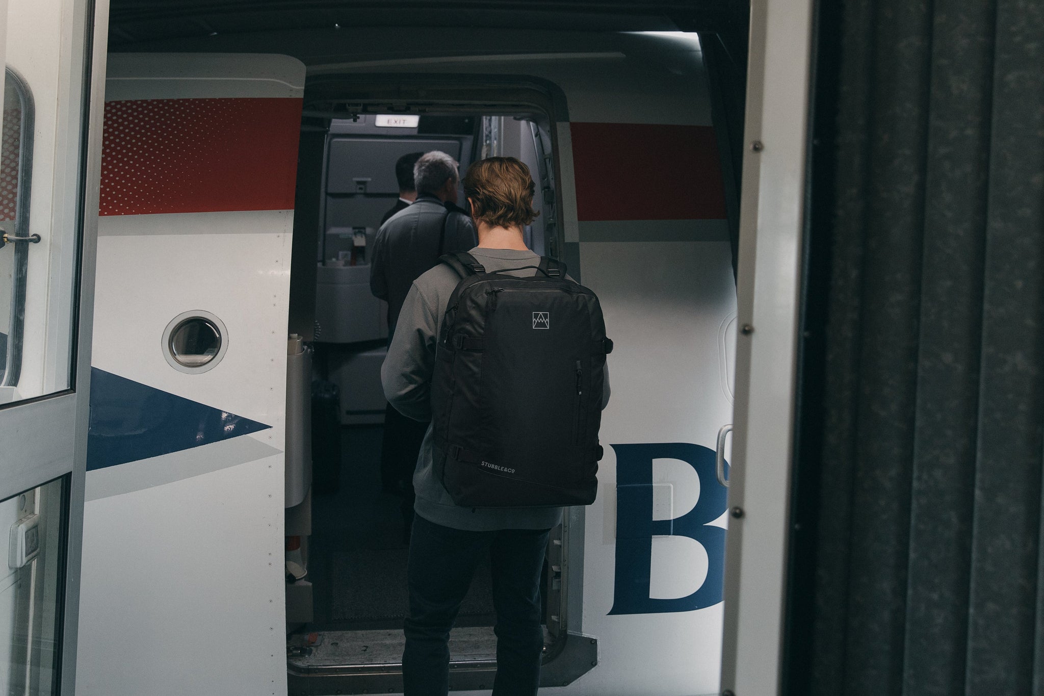 Man walking onto airplane with backpack