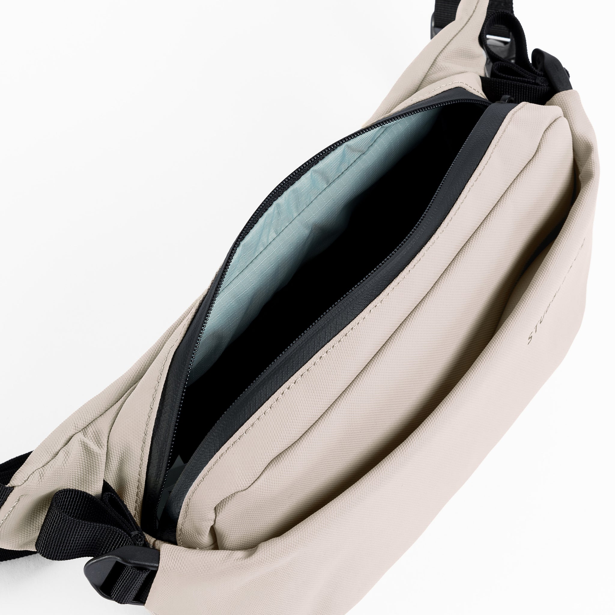A studio shot of the interior of the Sand Crossbody  showing the blue lining