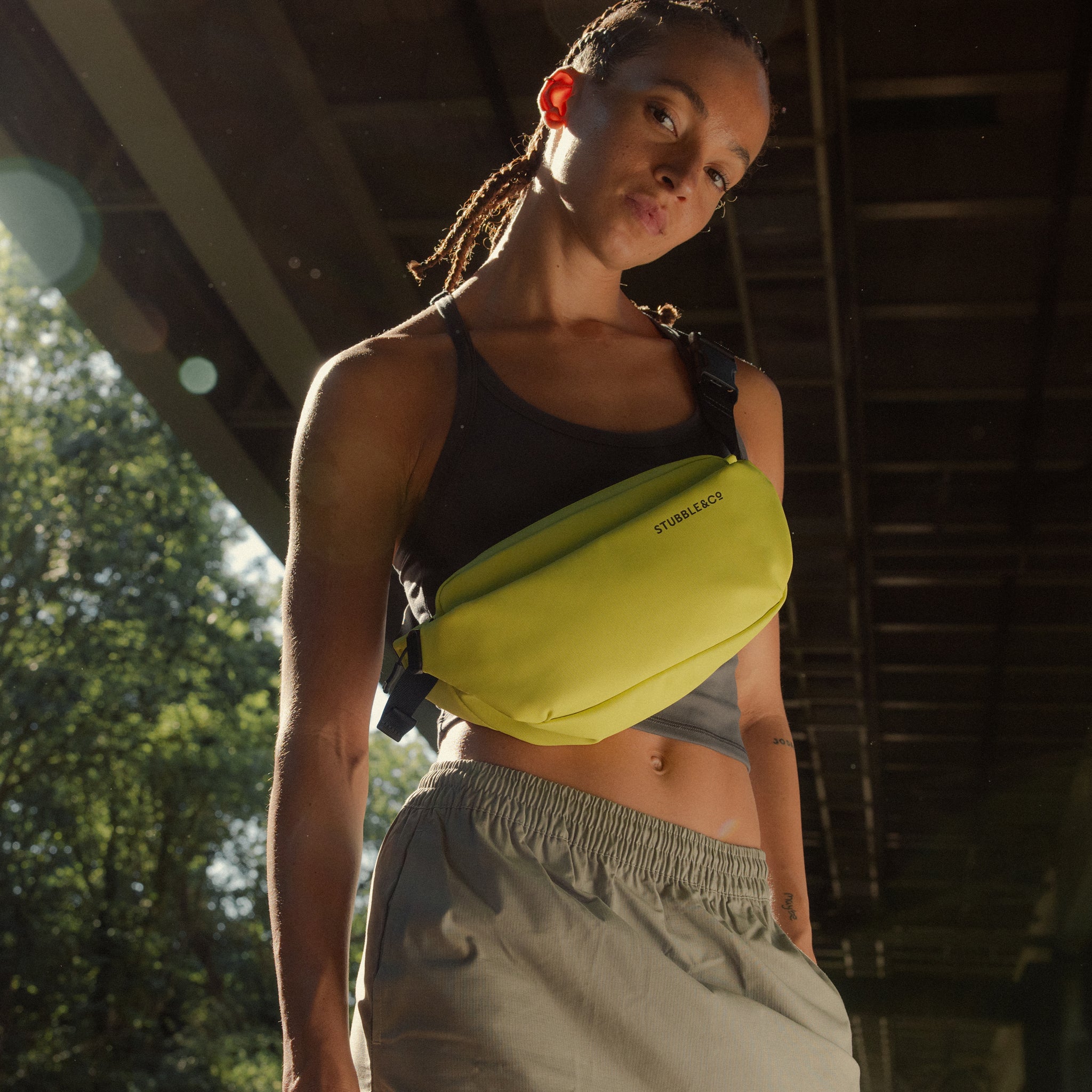 A woman standing in the sun wearing a Volt Crossbody by Stubble & Co across her front
