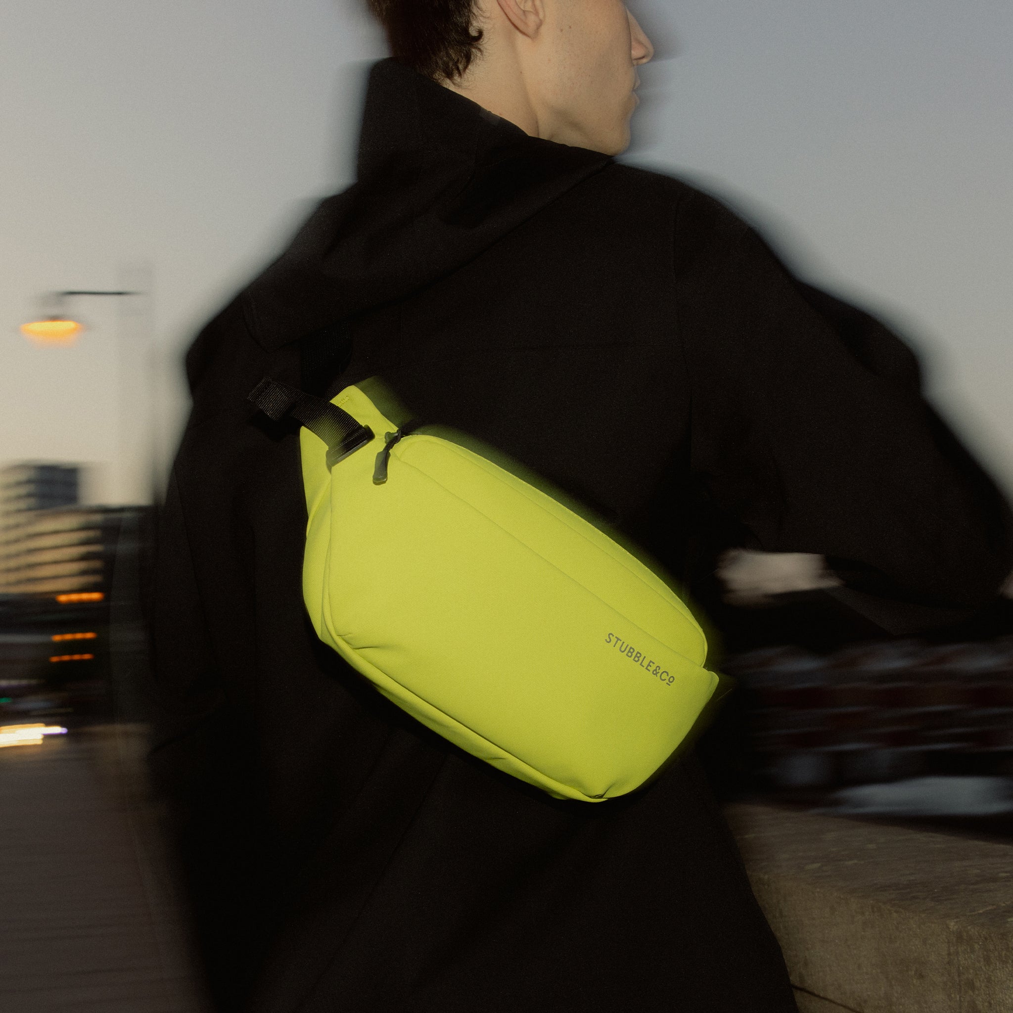 A man wearing a Volt Crossbody on his back at sunset
