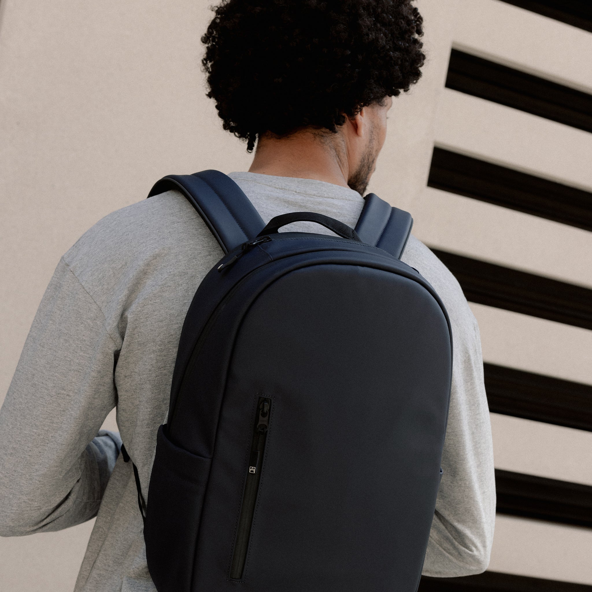 A man wearing an Everyday backpack 15L on his back in Midnight Blue