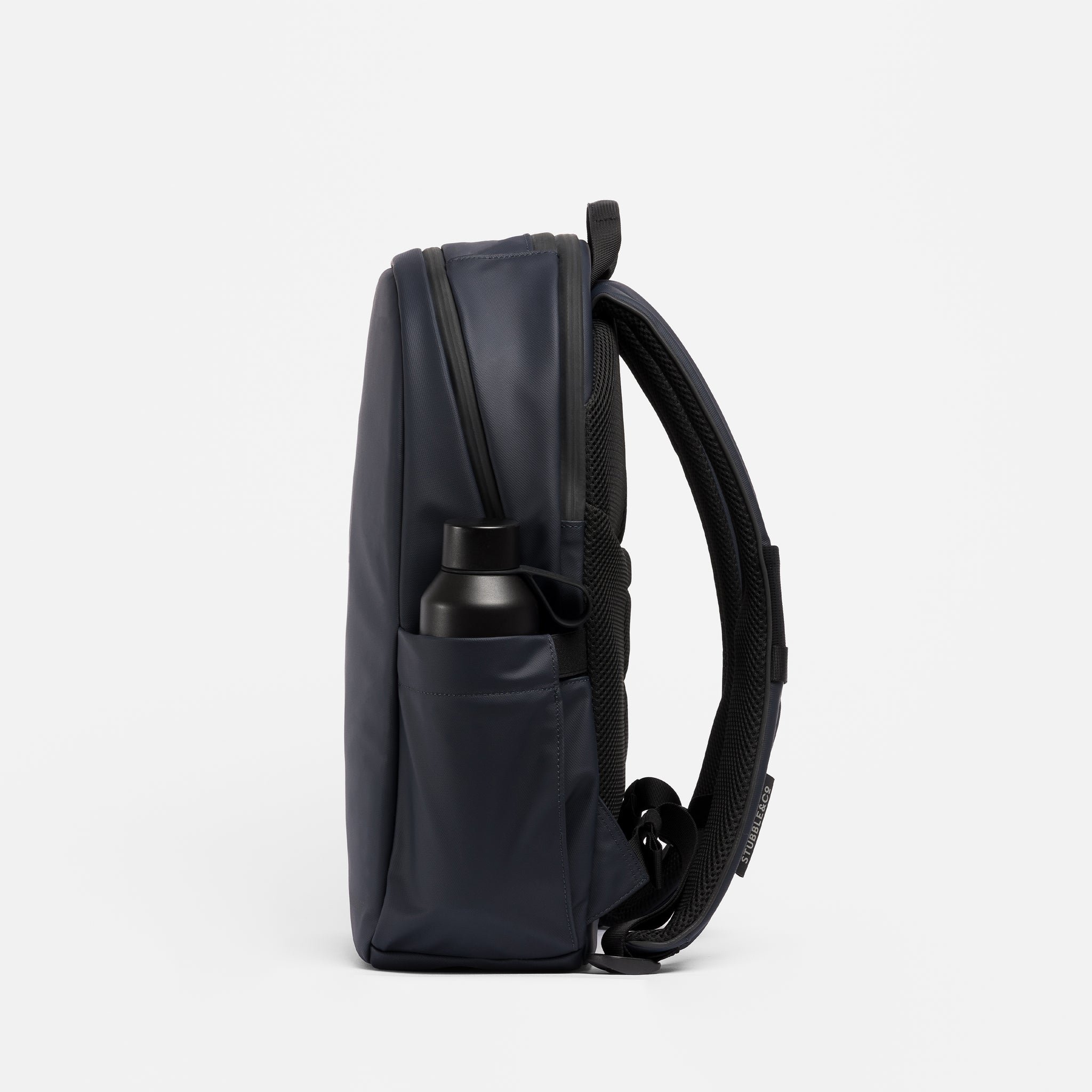 A studio shot of an Everyday Backpack 15L in Midnight Blue showing the elasticated side pocket