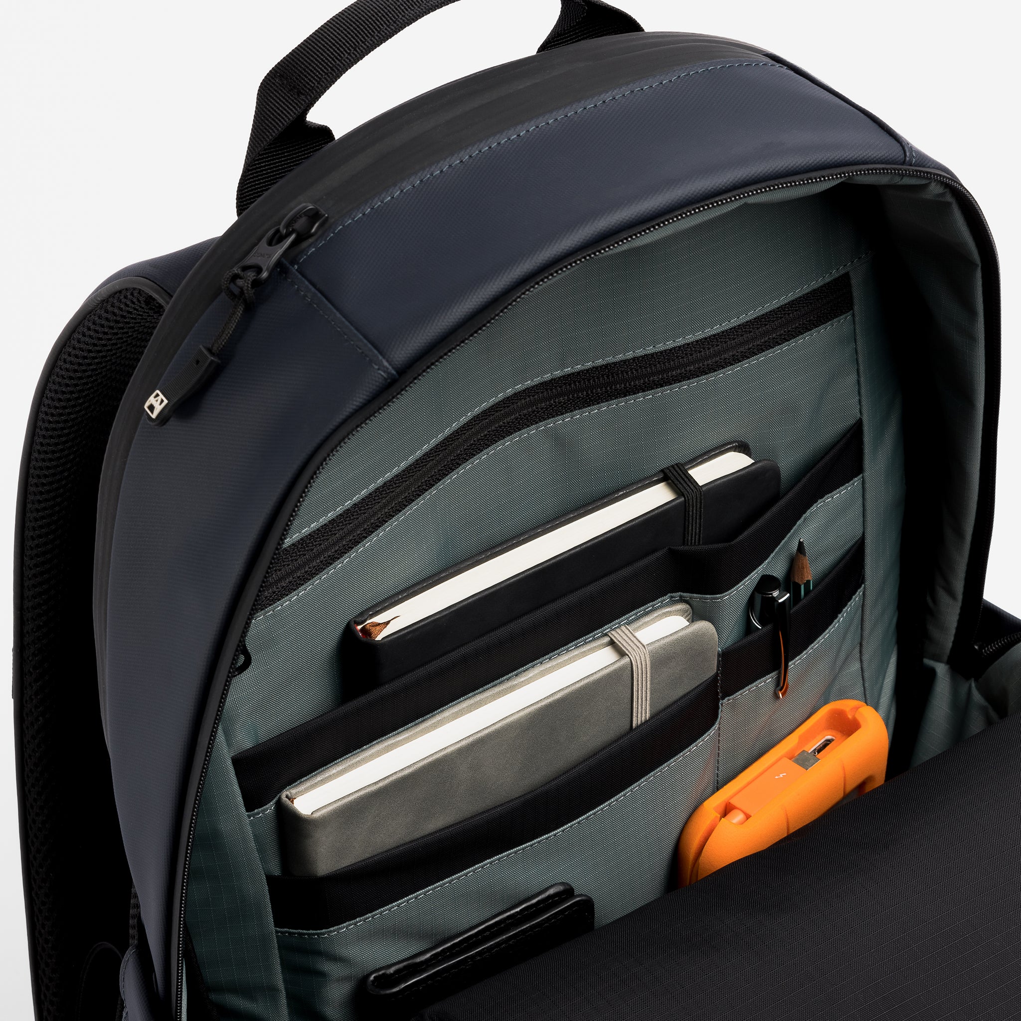 A studio shot of an Everyday Backpack 15L in Midnight Blue showing the interior organisation