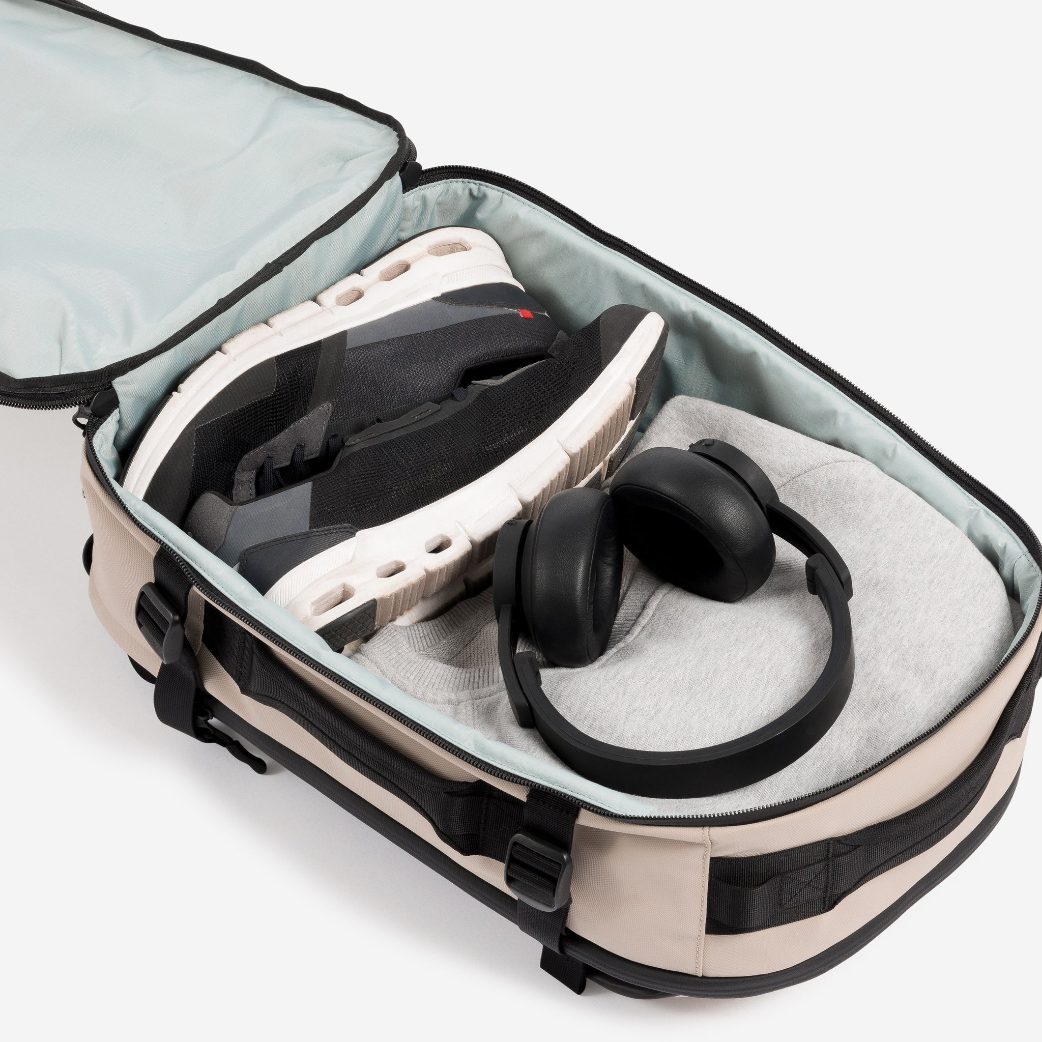 A studio shot of a packed interior compartment of the Hybrid Backpack 20L in Sand