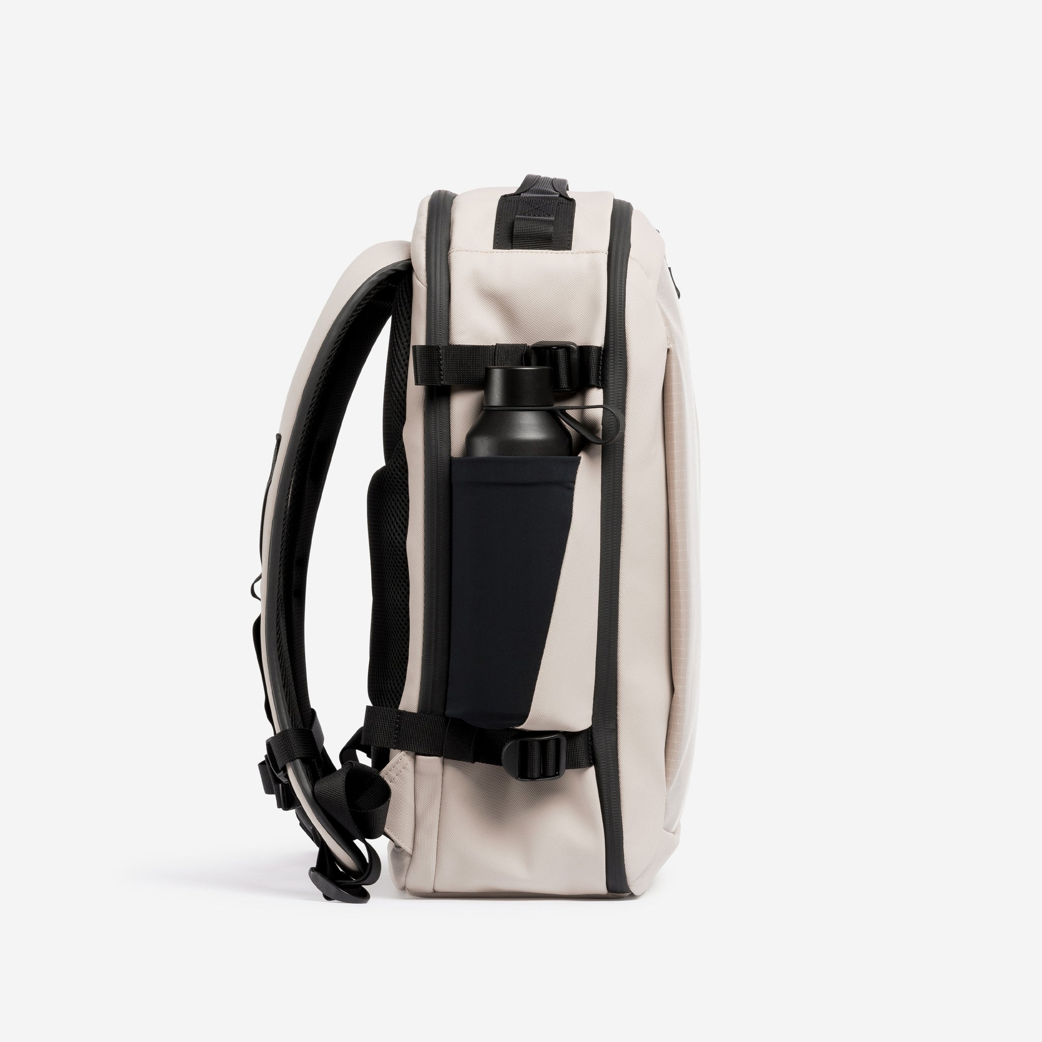 A studio shot of the elasticated side bottle pocket on the Hybrid Backpack 20L in Sand