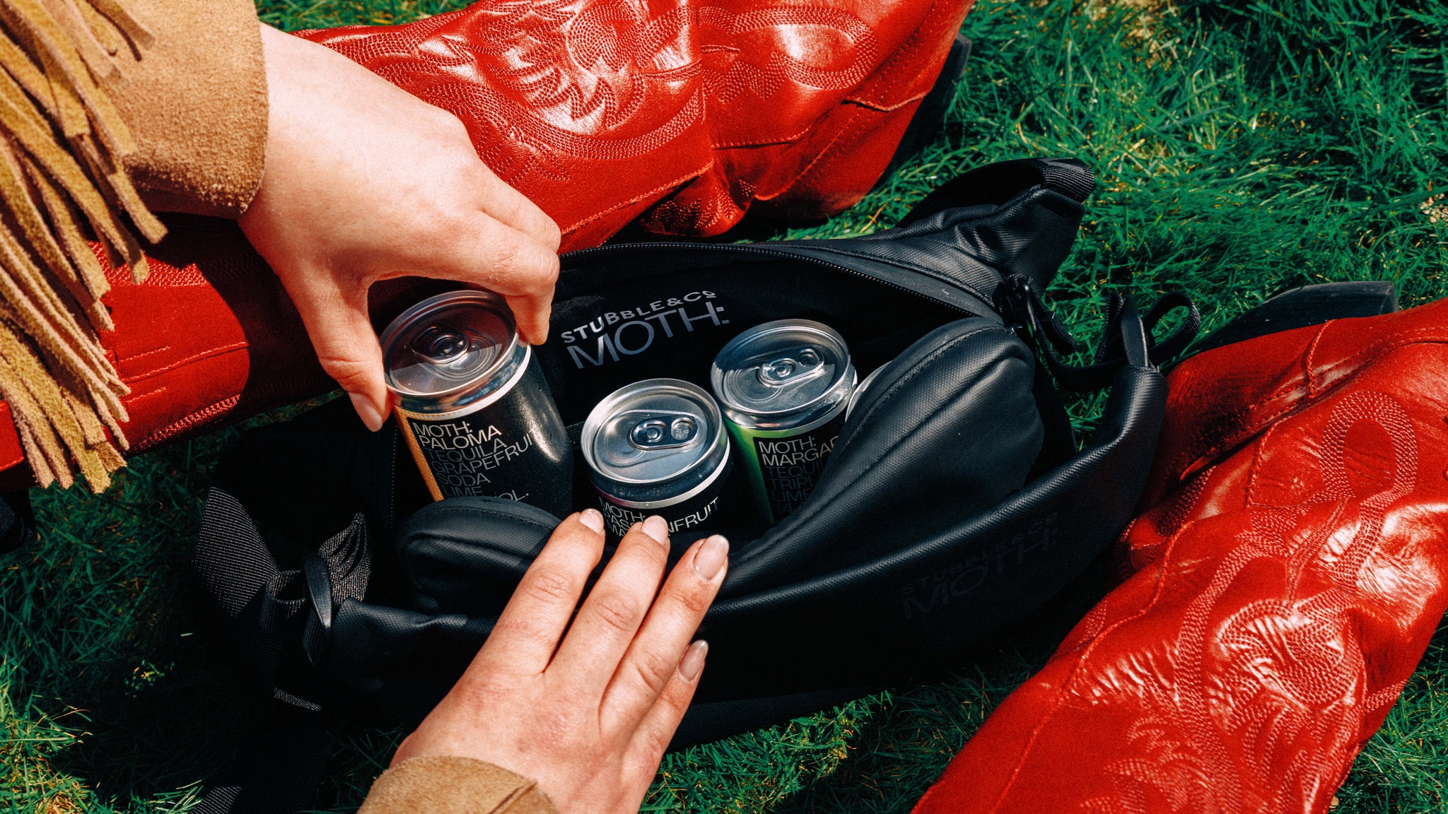 A woman getting moth drinks out of a the MOTH co-branded crossbody