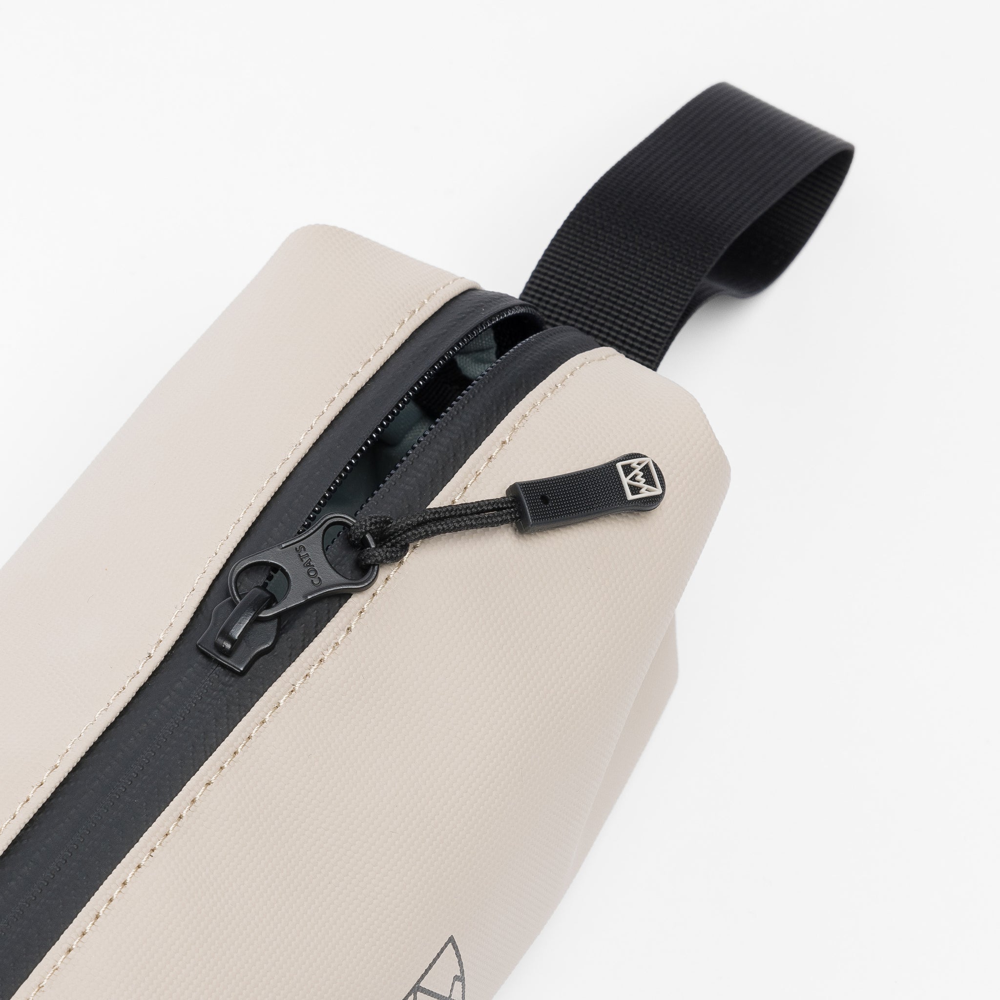 A studio shot of the zips and loop handle of the Pencil Case in Sand