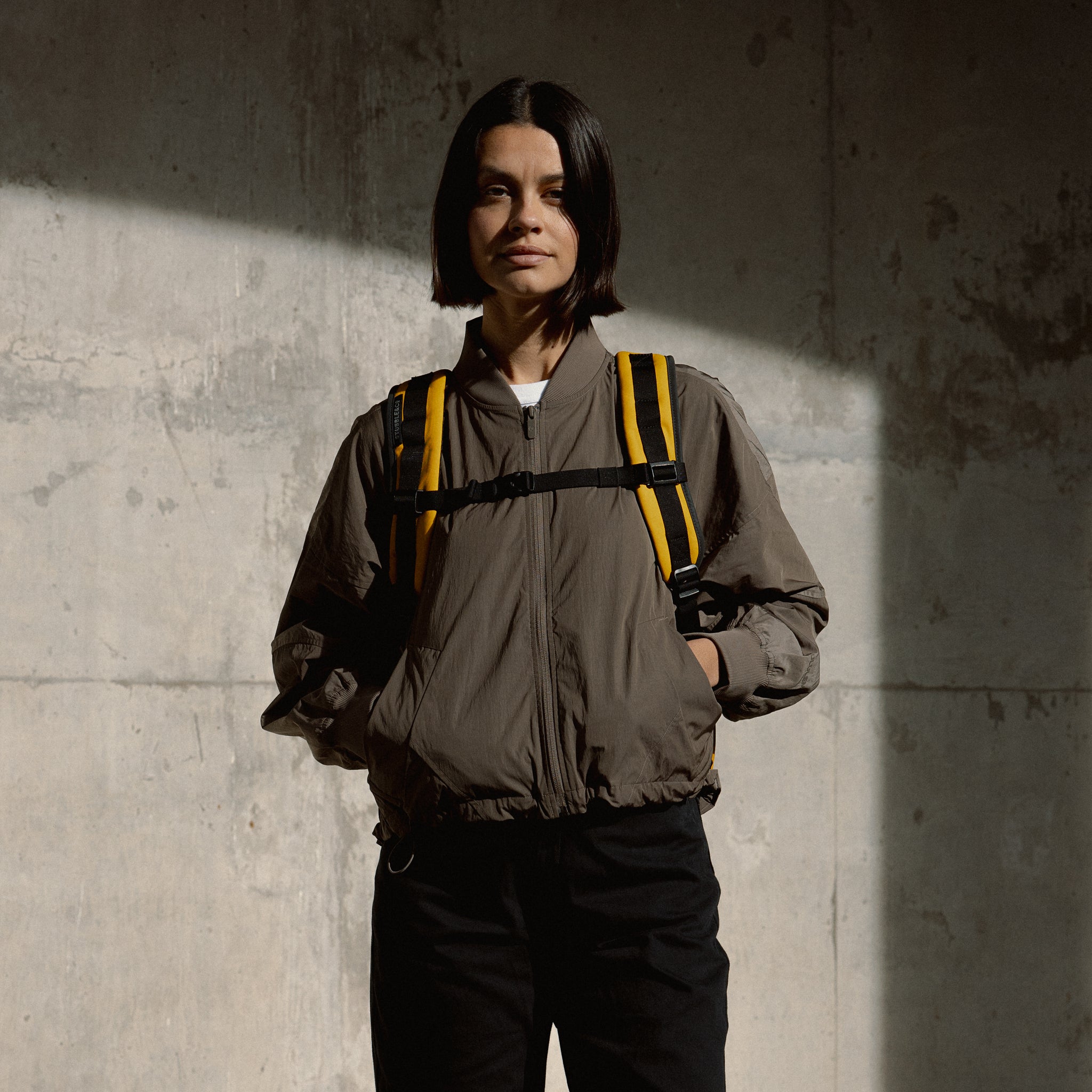 a woman wearing the Yellow roll top 15l and it shows the adjustable chest straps