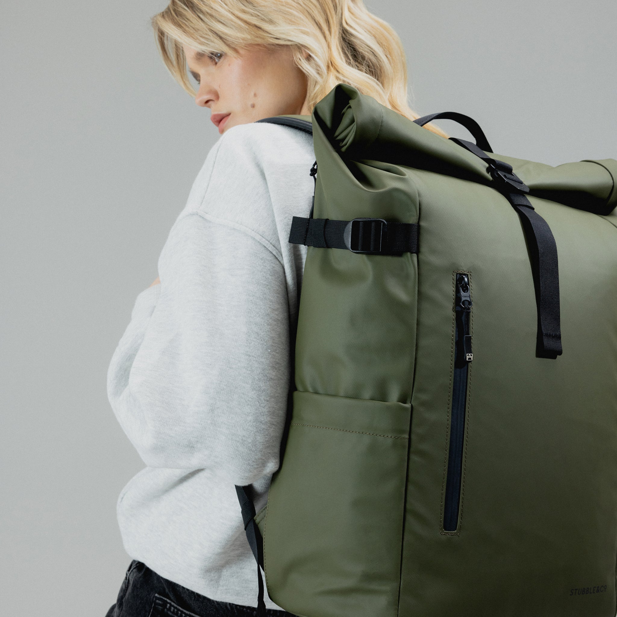 A woman wearing an Urban Green Roll Top 30L on her back