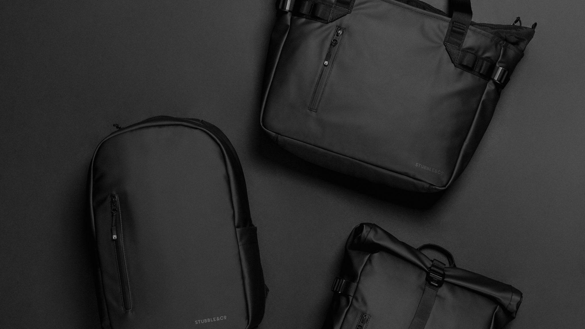 A studio shot of the tote bag, everyday backpack and roll top 20l lying on a black background for a rpet collection photo