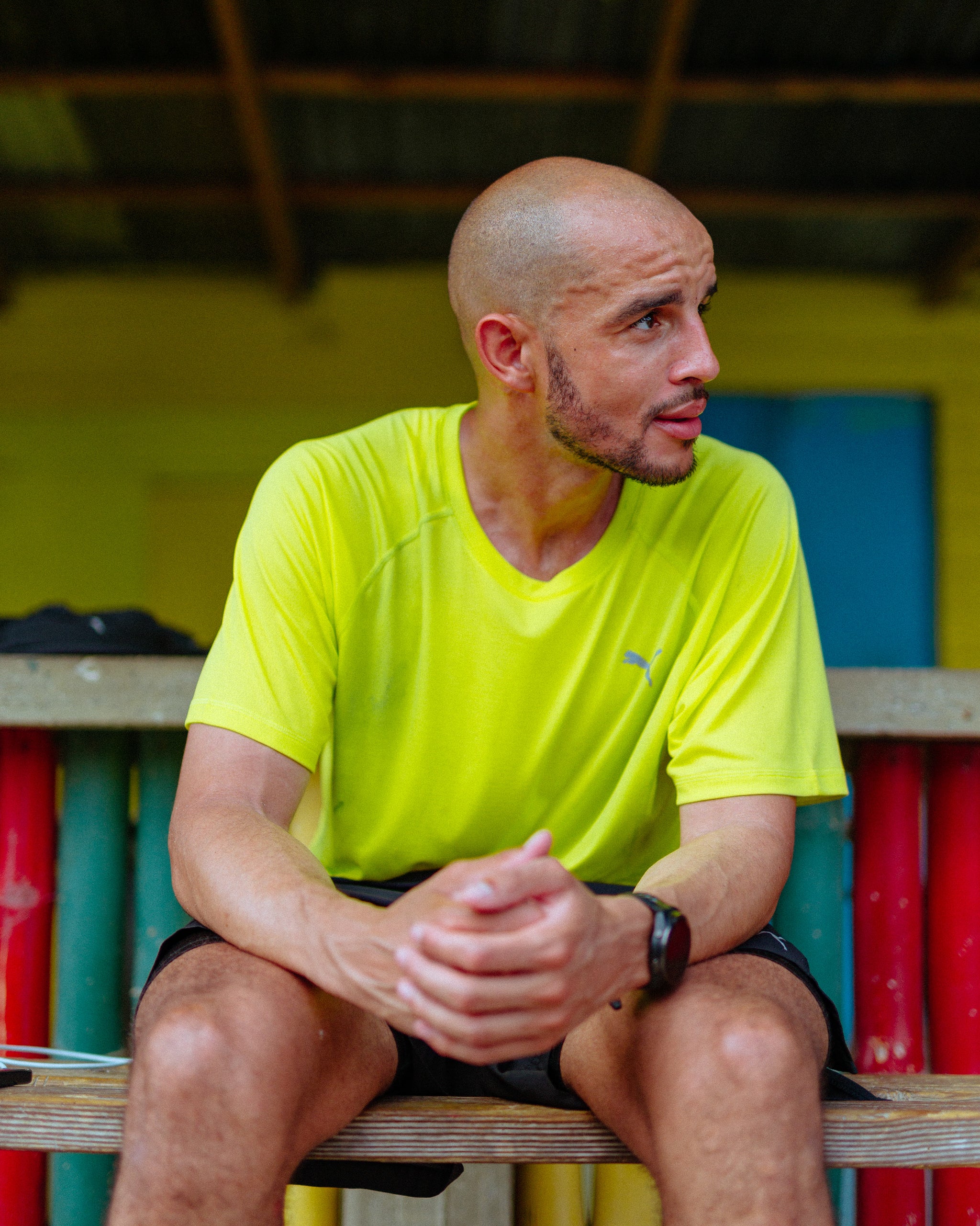 A man sitting down on a wooden bench