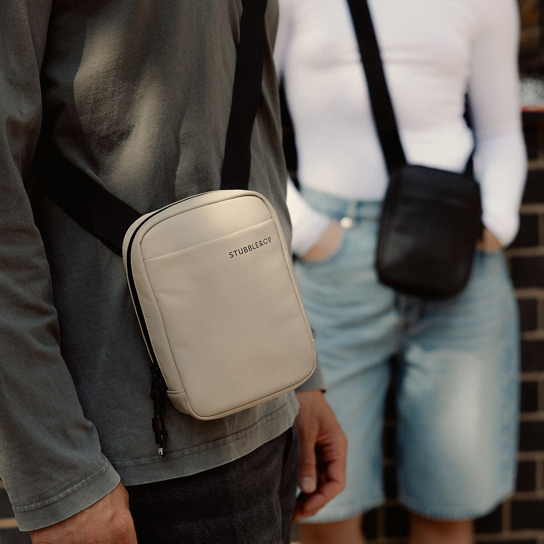 a close up of a man wearing a Sand shoulder bag