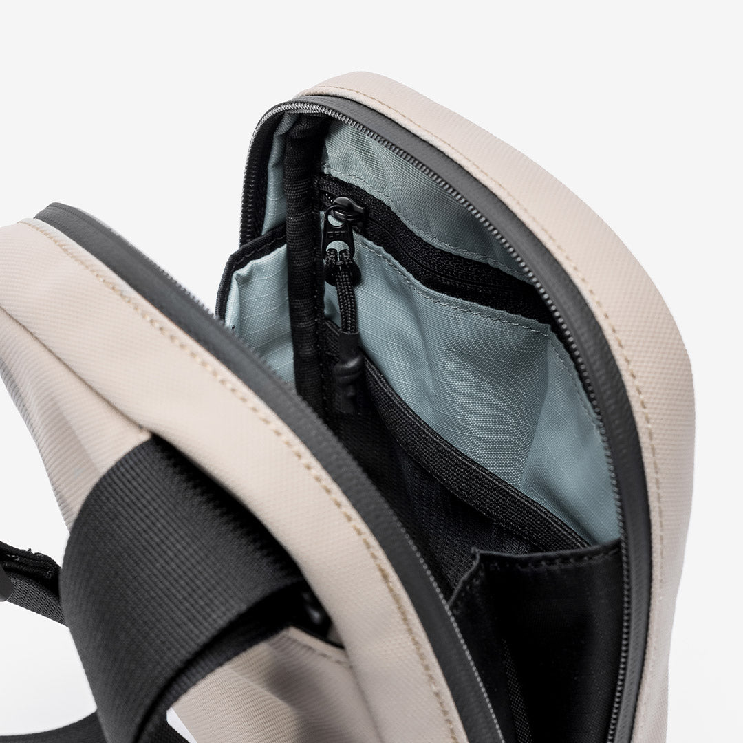 a studio shot of the blue lining and interior pockets in Sand shoulder bag