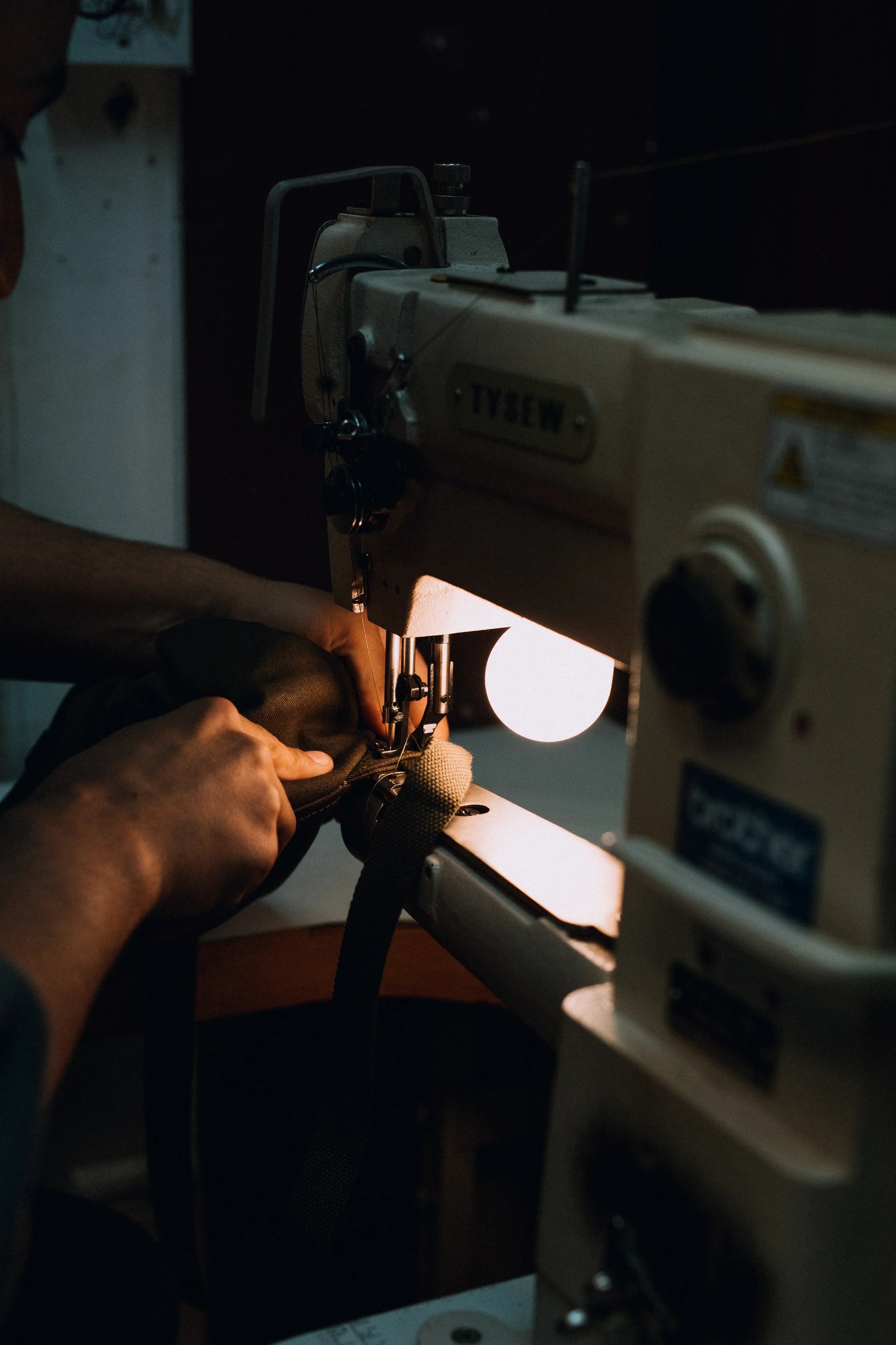 Close up of person using sewing machine