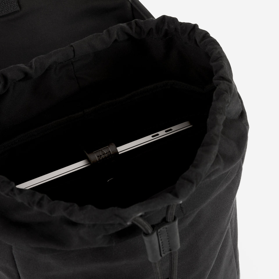 Inside a black backpack with laptop showing in internal compartment