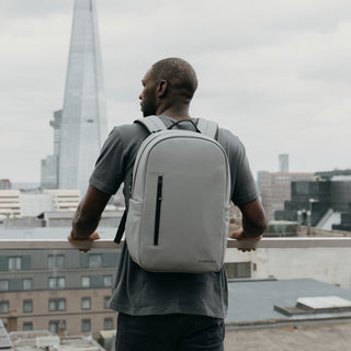Man wearing Concrye Everyday Backpack looking over a balcony.