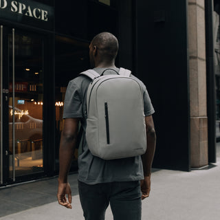 Man wearing large grey backpack walking towards doors