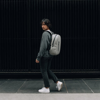 Women wearing grey backpack standing on street