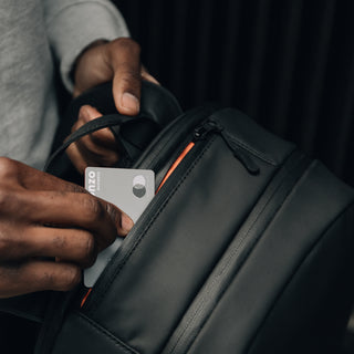 Credit card going into zip pocket on black bag