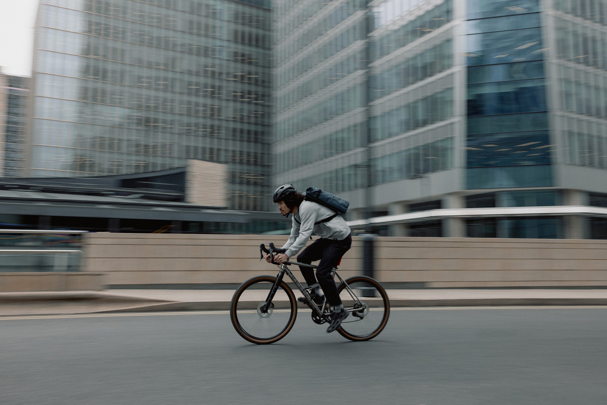 Person riding a bicycle in an city setting with buildings in the background