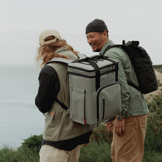 A man wearing The Cooler in Concrete stood next to a man wearing The Roll Top in All Black.