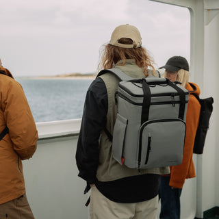 A man wearing a Concrete Cooler while stood on a boat.