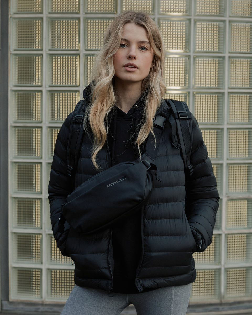 Women wearing a black coat and black crossbody bag