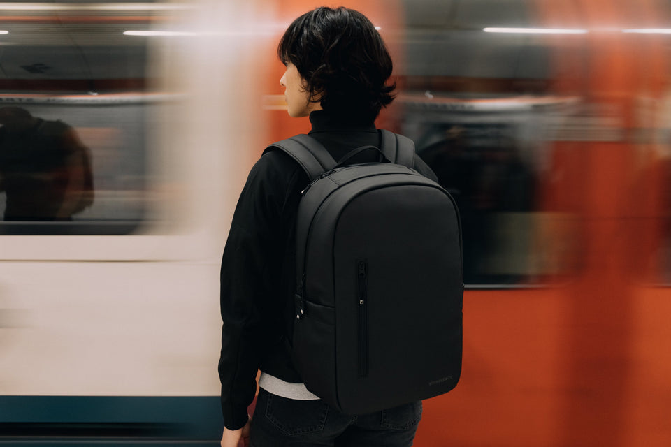 Women with black Everyday Backpack by a train