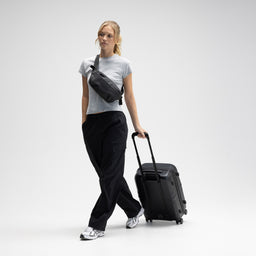 A female model walking with  the Hardshell 40L in All Black