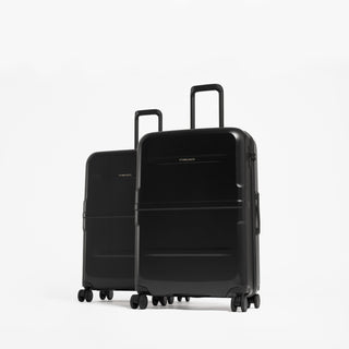 Two black hard-shell spinner suitcases with the larger suitcase in front and a smaller one behind. [All variants]