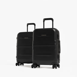 Two hardshell carry-on suitcases in black standing side by side, one in front of the other, on a white background. [All variants]