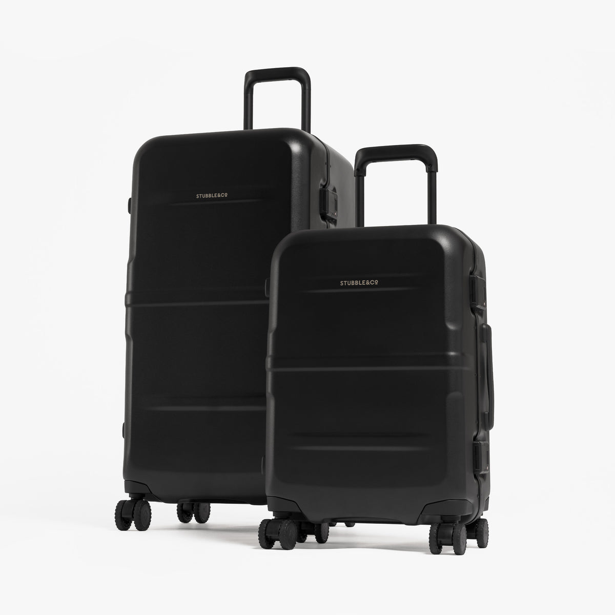 Two hard-shell spinner suitcases in black, one larger and one smaller, standing upright on a clean white studio background. [All variants]