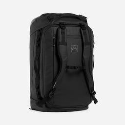 All Black duffel bag with multiple zippered compartments and padded shoulder straps, shown from a three-quarter angle against a light gray background.