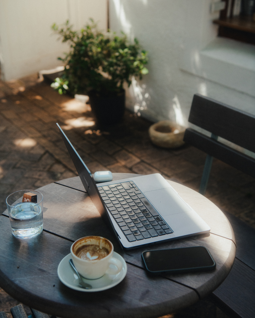 Laptop and coffee on table outside of Pauline's Cafe in Cape Town