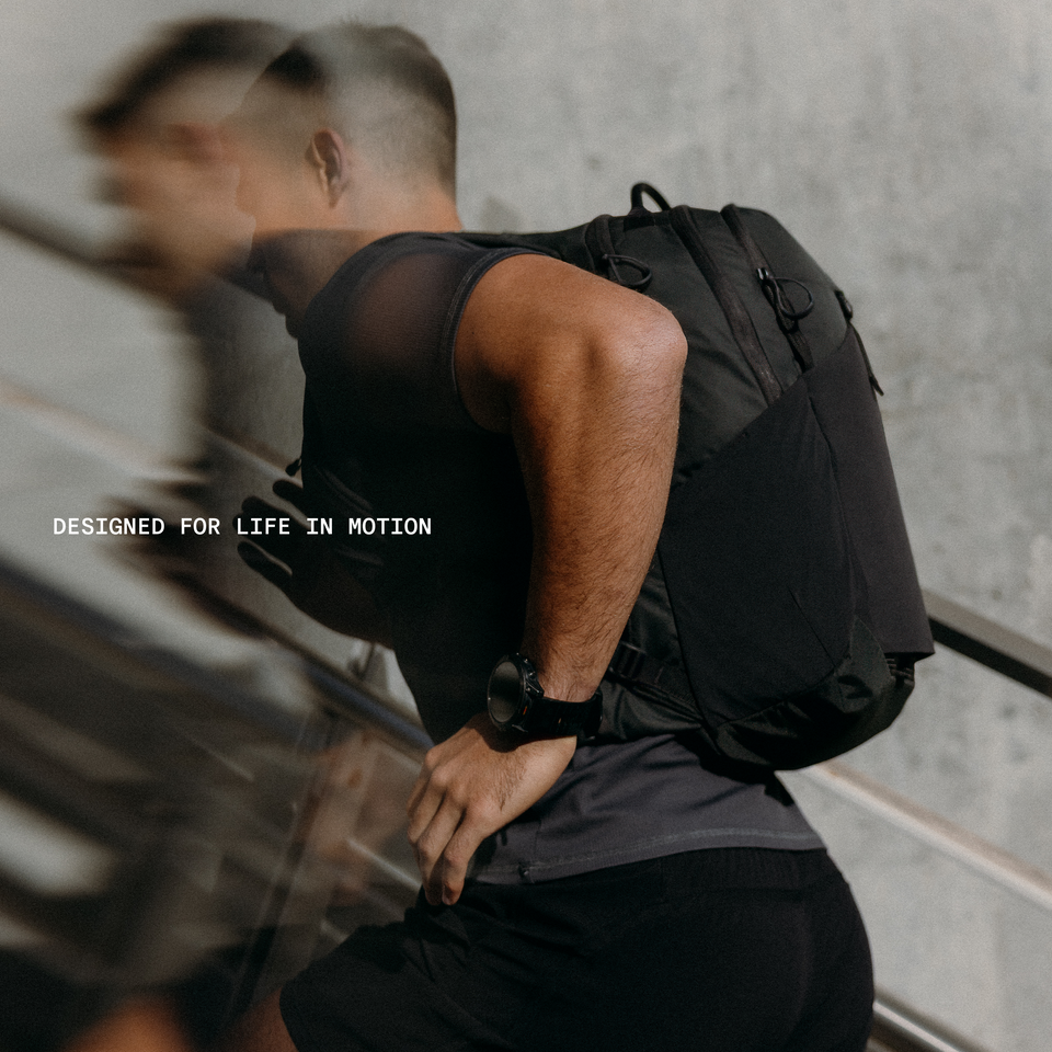 A man running with a motion backpack 20l in charcoal on his back with a blur effect and the range slogan annotated-"designed for life in motion"