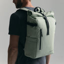 Man wearing the Roll Top Backpack in Matcha green