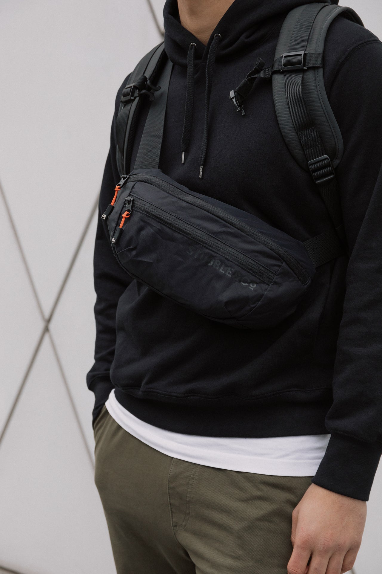 A man wearing an All Black Ultra Light packable sling