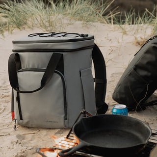 Cooler bag in grey concrete on a beach with a BBQ