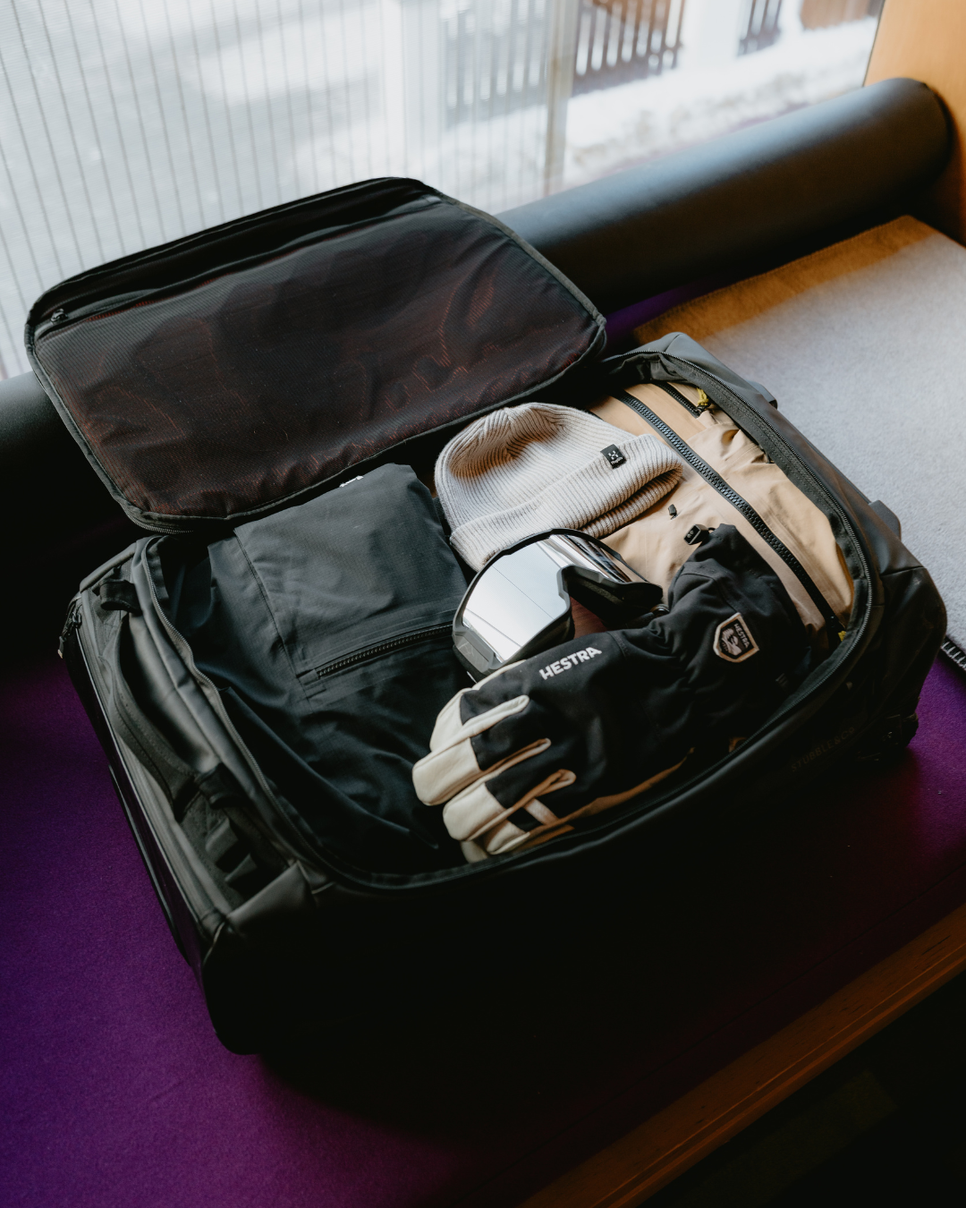 Open suitcase with ski gear inside