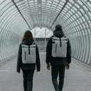 Man and women wearing a Concrete grey Roll Top backpacks in a tunnel