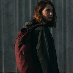 Women wearing an Earth Red Roll Top backpack