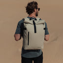 Man on beach wearing The Sand Roll Top with back to camera