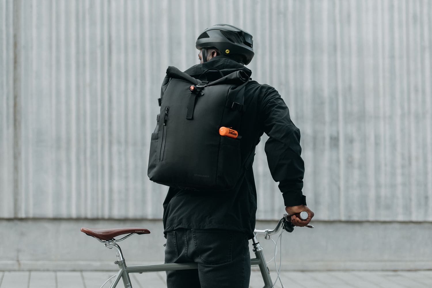 man on his bike wearing a black roll top bag