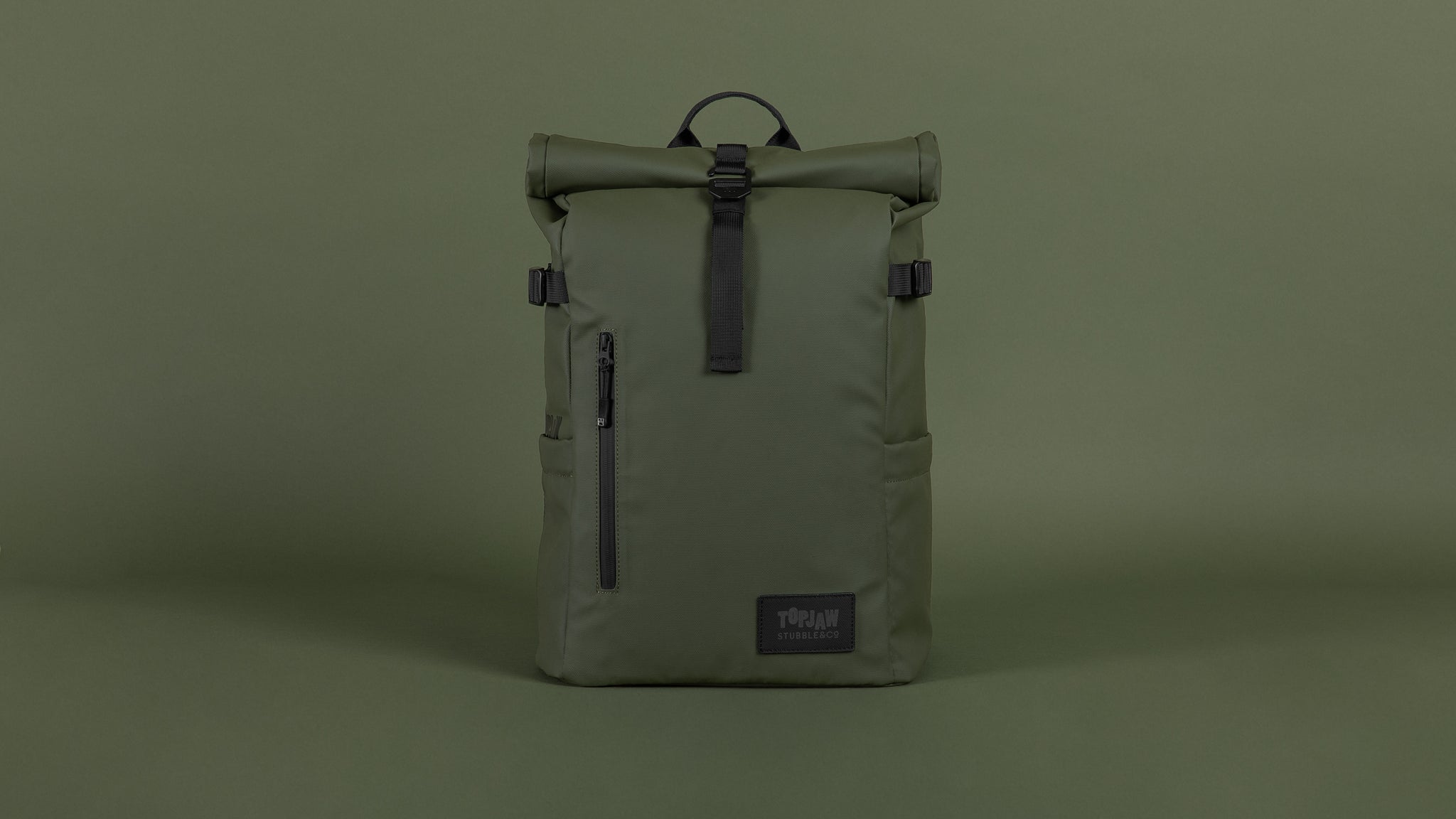 A studio shot of customised topjaw green roll top backpack on a green background