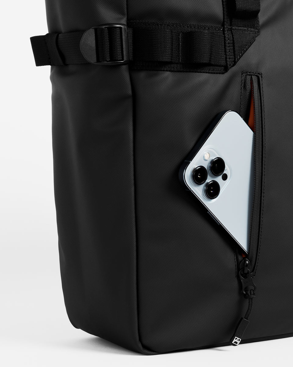 Close up of black tote bag with pocket holding a mobile phone