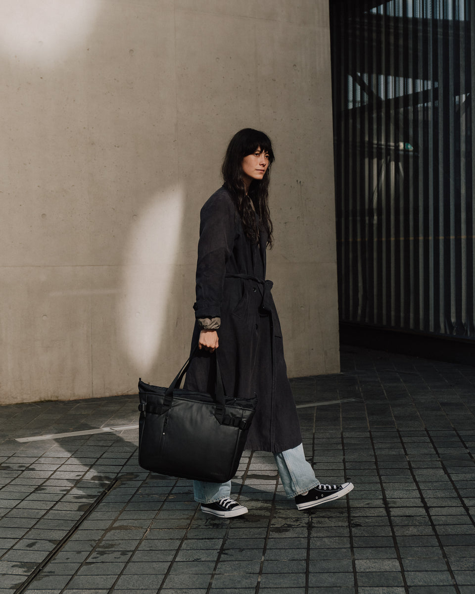 Women carrying a black tote bag