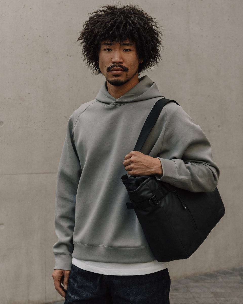 Person carrying a black tote bag