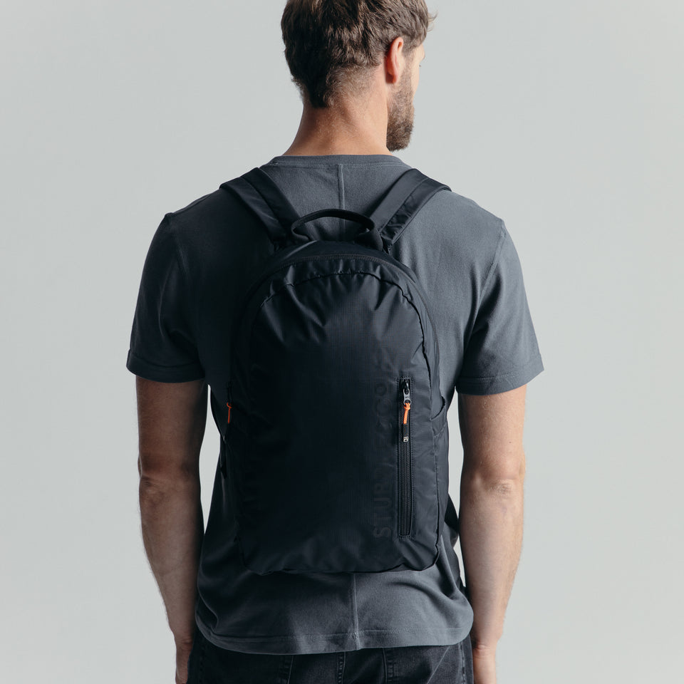 Man wearing the packable All Black Ultra Light Backpack