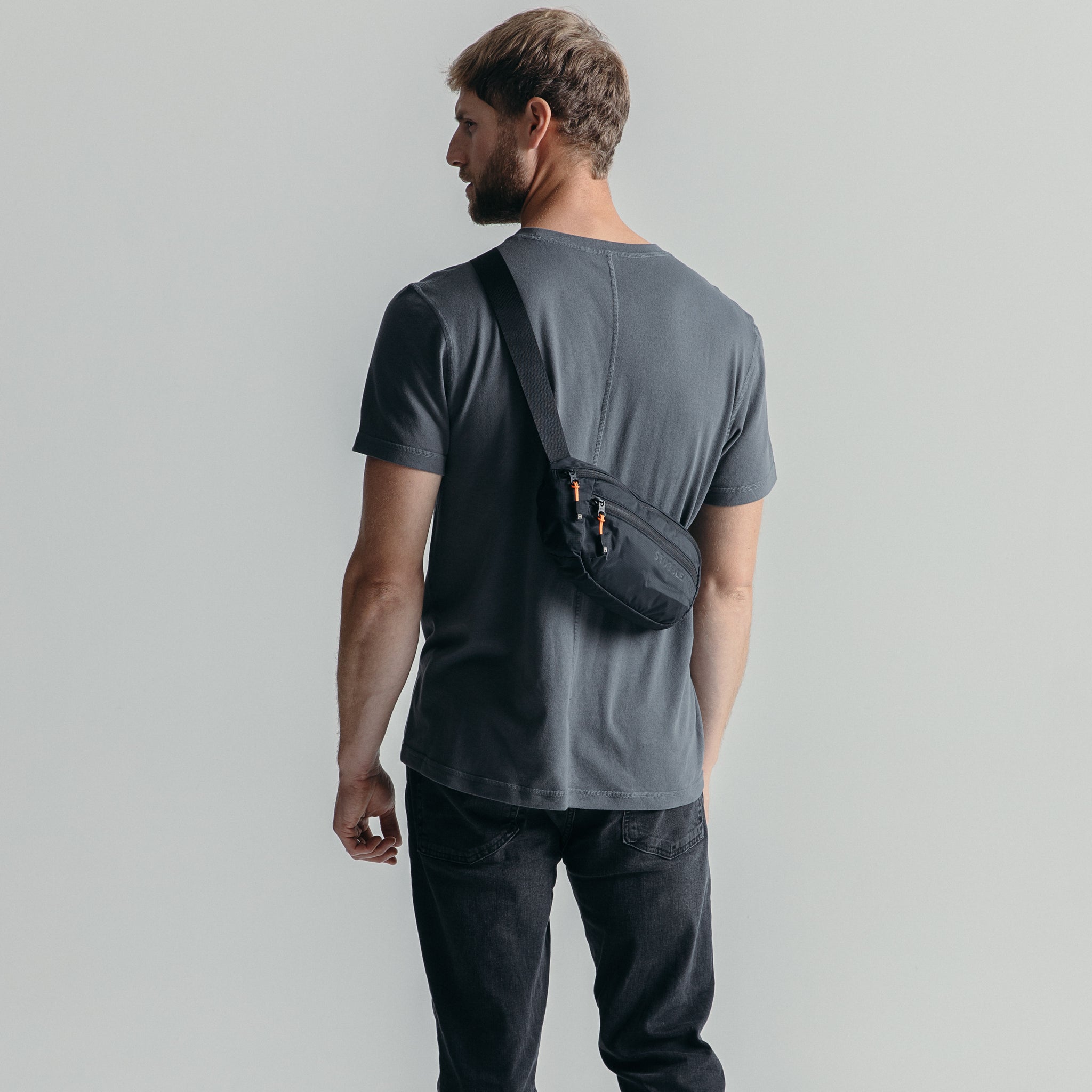 Man wearing the All Black packable Ultra Light Crossbody Bag