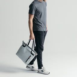 Man using the Off White packable Ultra Light Tote Bag